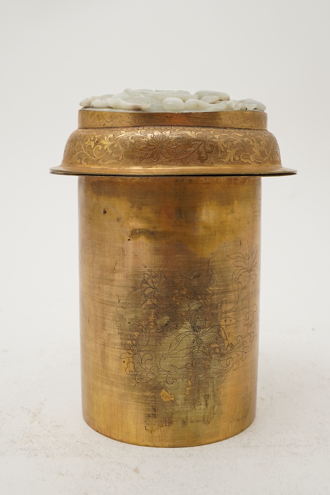 A Chinese pale celadon jade oval plaque, 17th/18th century, mounted on a late Qing gilt copper jar